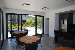 Una cucina moderna con forno integrato e zona pranzo con tavolo e sedie in legno.