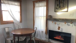 Ein gemütliches Zimmer mit Kamin, Holzmöbeln und Vorhängen.