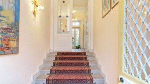 A staircase with ornate carpeted steps leading to a door. - Apartment in the middle of a wine paradise (Rhodt unter Rietburg)