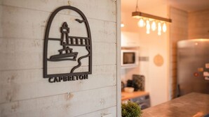 Un logo représentant un phare et le mot « Capbreton » sur un mur.