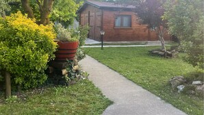 A wooden cabin with a paved pathway leading to it, surrounded by lush greenery and trees. - Charming chalet with WiFi and AC in lovely Rubano (Rizzi)