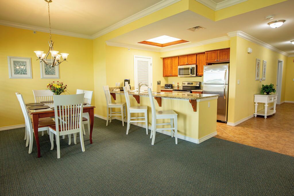 A compact kitchen with wooden cabinets, a microwave, and a refrigerator.