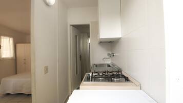 Een koelkast, een kinderstoel, kookgerei, borden en bestek