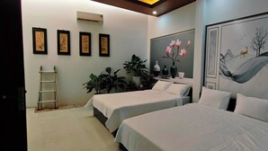A hotel room with two beds, a ladder, and a wall with framed artwork. - Mai Viên Homestay & Restaurant (Hue)