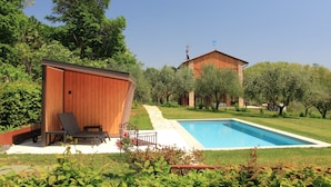 A pool area with a wooden deck, lounge chairs, and a small shed. - Villa Montello Pool Jacuzzi Ac Wifi  (Volpago del Montello)