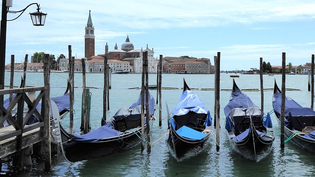 Gondolas docked at a pier with a historic building in the background. - Villa Montello Pool Jacuzzi Ac Wifi  (Volpago del Montello)