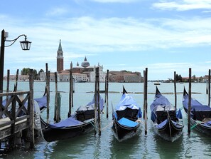Gondolas docked at a pier with a historic building in the background. - Villa Montello Pool Jacuzzi Ac Wifi  (Volpago del Montello)