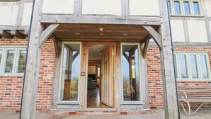 A traditional half-timbered building with a wooden entrance and large windows. - Cuckoo Pen Cottage (Tenbury Wells)