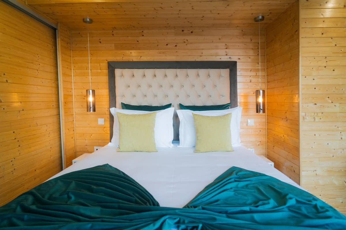 Ein Zimmer mit einem Bett, Holzwänden und zwei Wandleuchten.