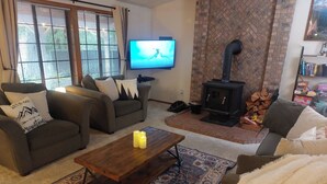 A cozy living room with a fireplace, a television, and a comfortable seating area.