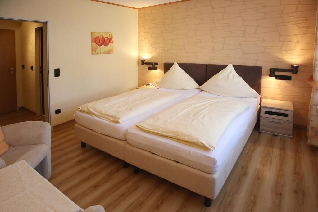Ein Doppelbett mit Kopfteil, Nachttischen und einem Bild an der Wand.