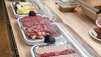 A buffet with various meats and cheeses.