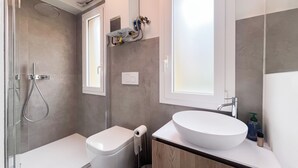 A modern bathroom with a toilet, sink, and shower. - Colorful studio- Bramante 41 (Milan)