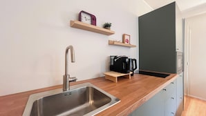 A modern kitchen with a stainless steel sink, wooden countertop, and a coffee maker. - Colorful studio- Bramante 41 (Milan)