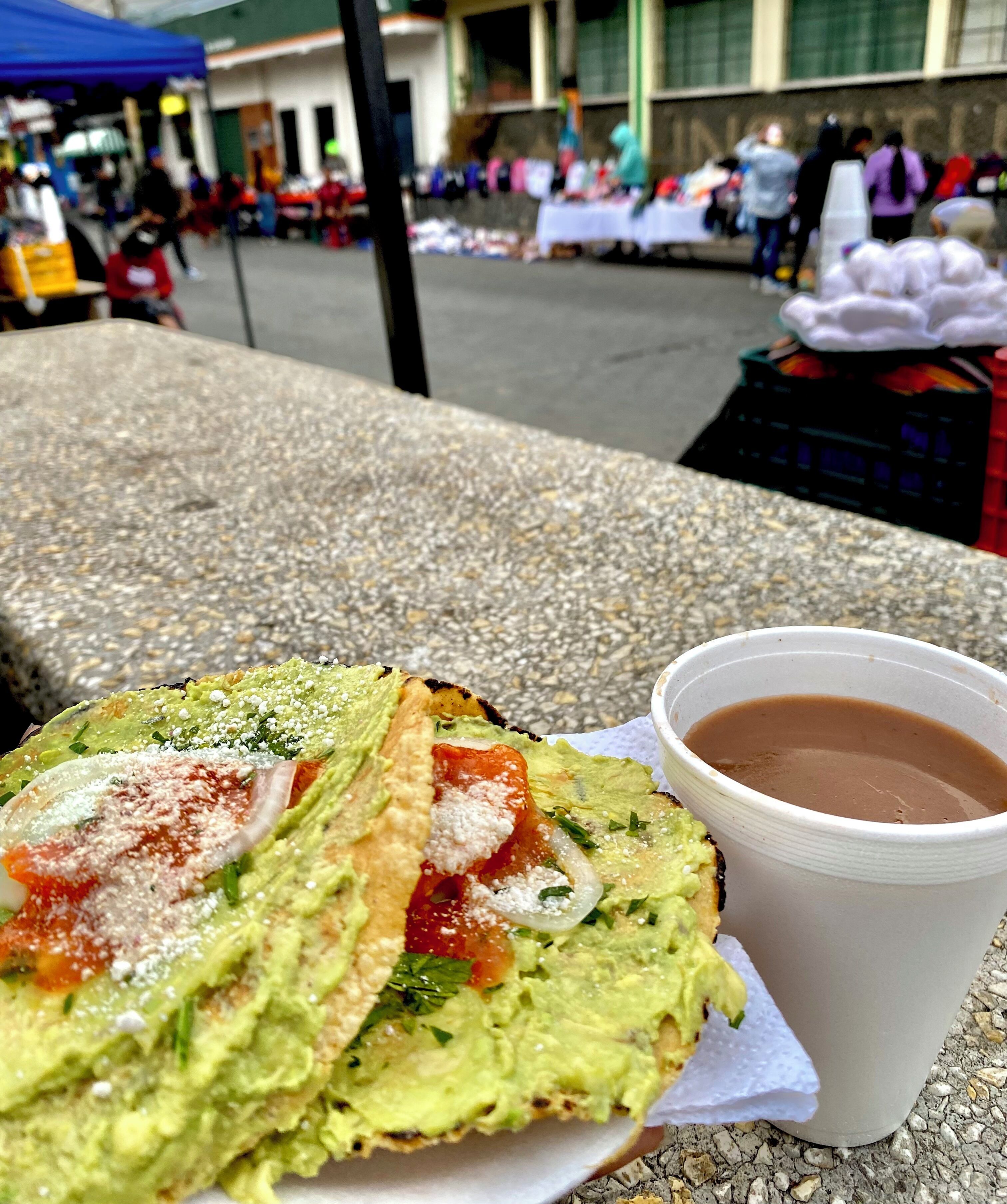 Una mesa con comida que incluye un wrap y una taza de café.