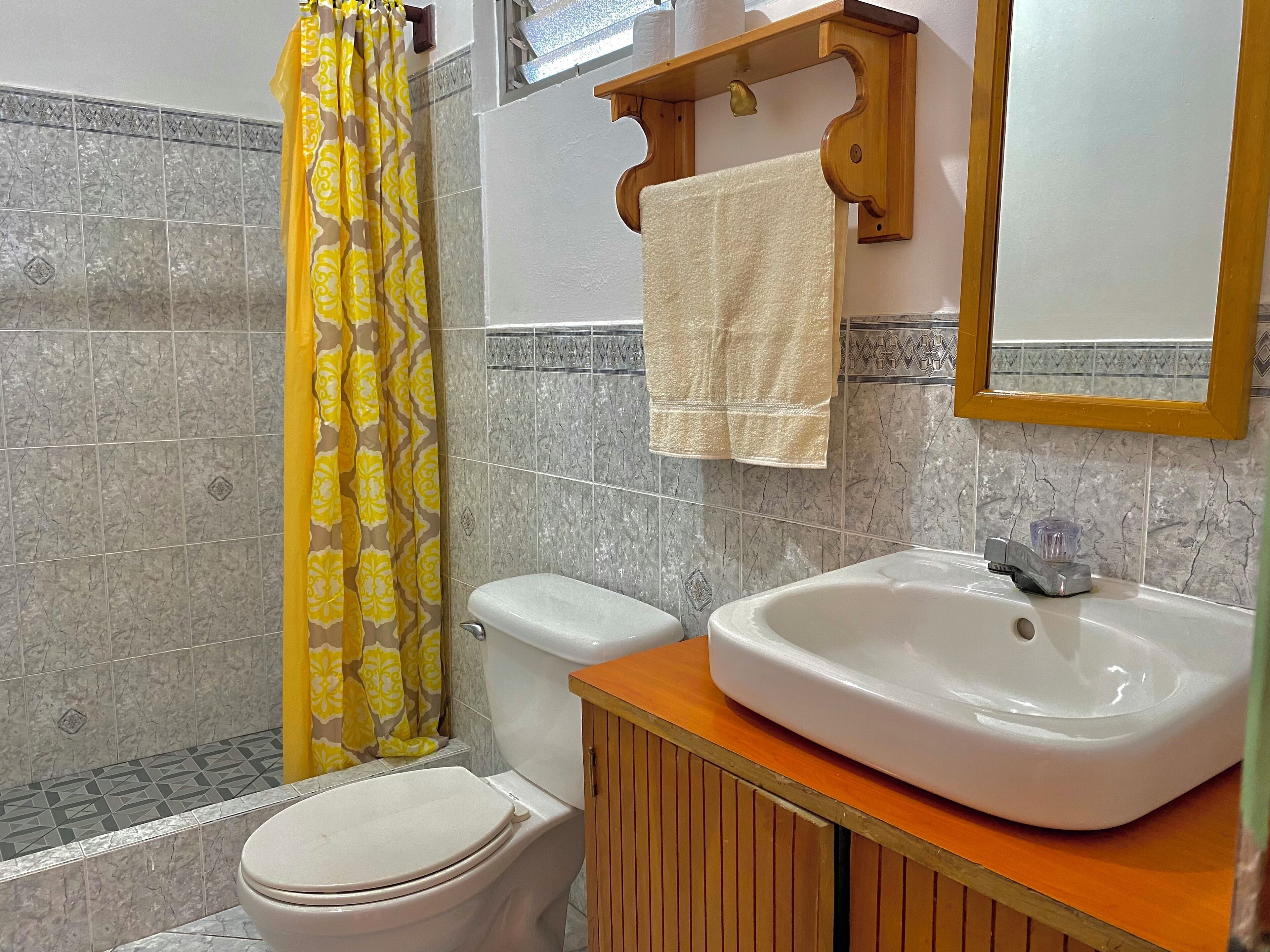 A bathroom with a toilet, a sink, and a shower curtain.