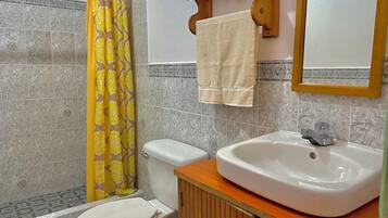 A bathroom with a toilet, a sink, and a shower curtain.