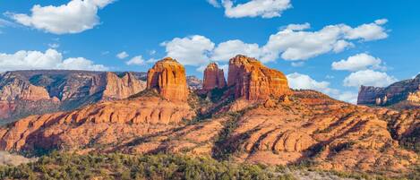 A mountainous landscape with prominent rock formations and a clear blue sky.