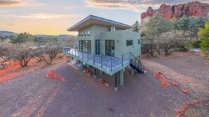 A modern house with a balcony, surrounded by trees and a rocky landscape. - Moondance Redrock Terrace Sedona (Sedona)