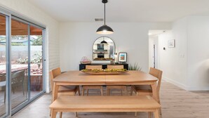 A dining area with a wooden table, benches, and a hanging pendant light. - NEW Redrock Experience Views Firepit Hottub (Sedona)