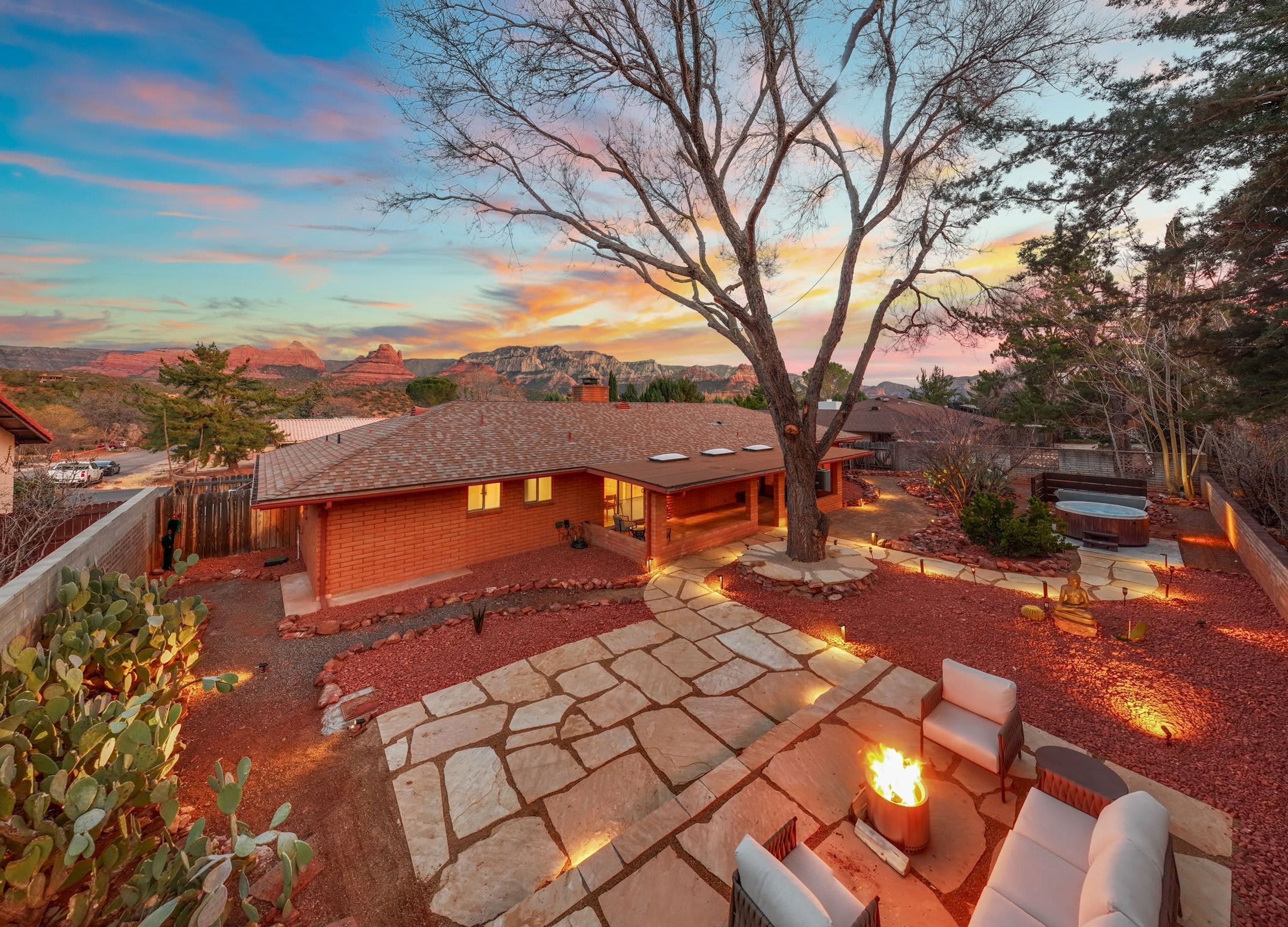 A house with a stone patio, outdoor seating, and a fire pit.