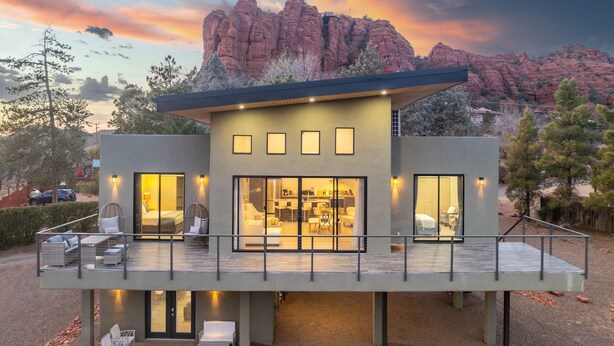 A modern two-story house with a balcony, large windows, and a view of red rock formations. - NEW Moondance Red Rock Retreat Epic Views (Sedona)