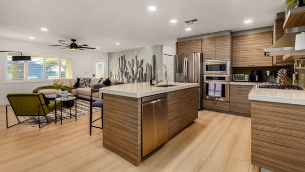 A modern kitchen with wooden cabinets, stainless steel appliances, and a central island.
