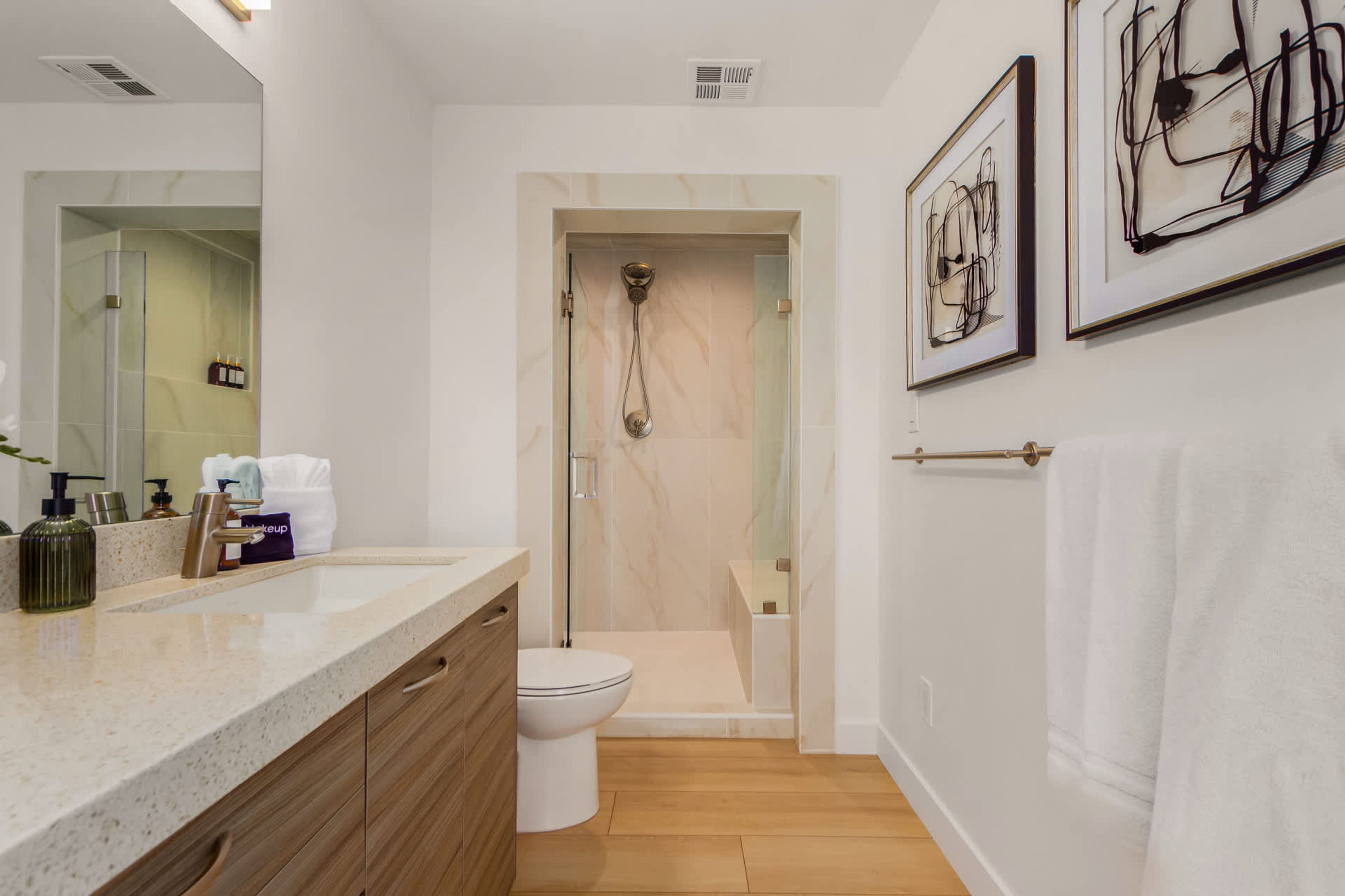 A modern bathroom with a shower, toilet, and vanity.