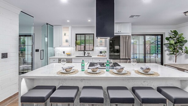 A modern kitchen with a central island, bar stools, and a large window. - NEW Sundancer Oasis Old Town Pool Spa Rooftop Deck (Scottsdale)