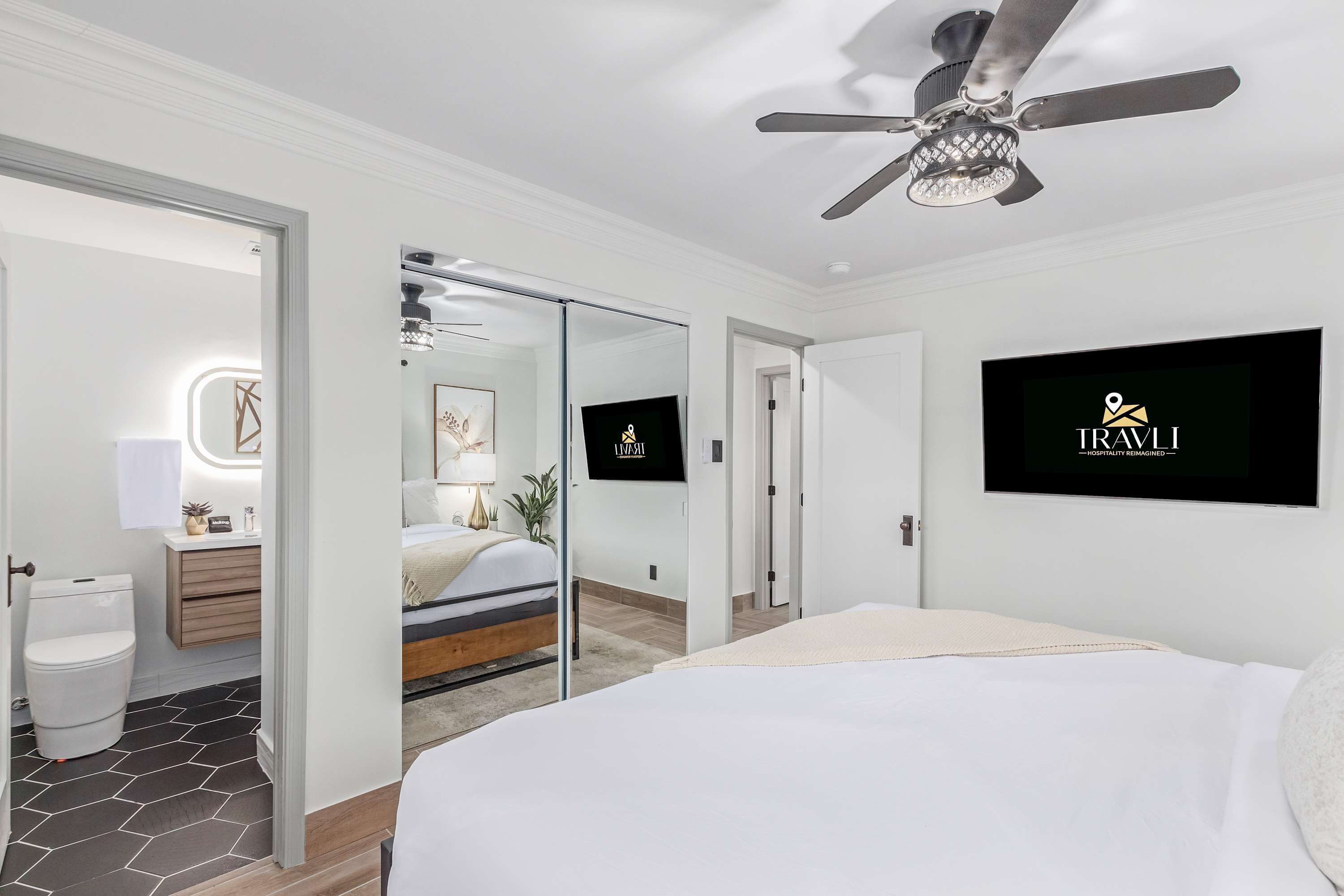 Une chambre d’hôtel équipée d’un lit, d’un ventilateur de plafond, d’une télévision et d’une salle de bain avec des toilettes et un lavabo.