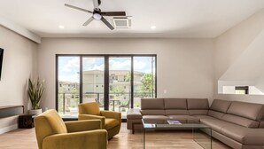 A modern living room with a sectional sofa, armchairs, a glass coffee table, and a ceiling fan. - Papago Lux Townhouse 4level Oasis w Rooftop Lounge (Scottsdale)