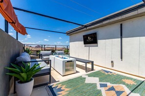 A modern outdoor seating area with a sofa, a coffee table, and a rug. - Papago Lux Townhouse 4level Oasis w Rooftop Lounge (Scottsdale)