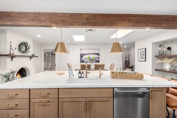 Enjoy cooking in this well-equipped kitchen with a central island, dishwasher, and pendant lights.