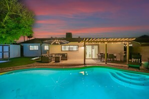 A backyard with a swimming pool, a covered patio, and a house with a garage. - Villa on Virginia 2 Masters Pool Hottub Sleeps 10 (Scottsdale)