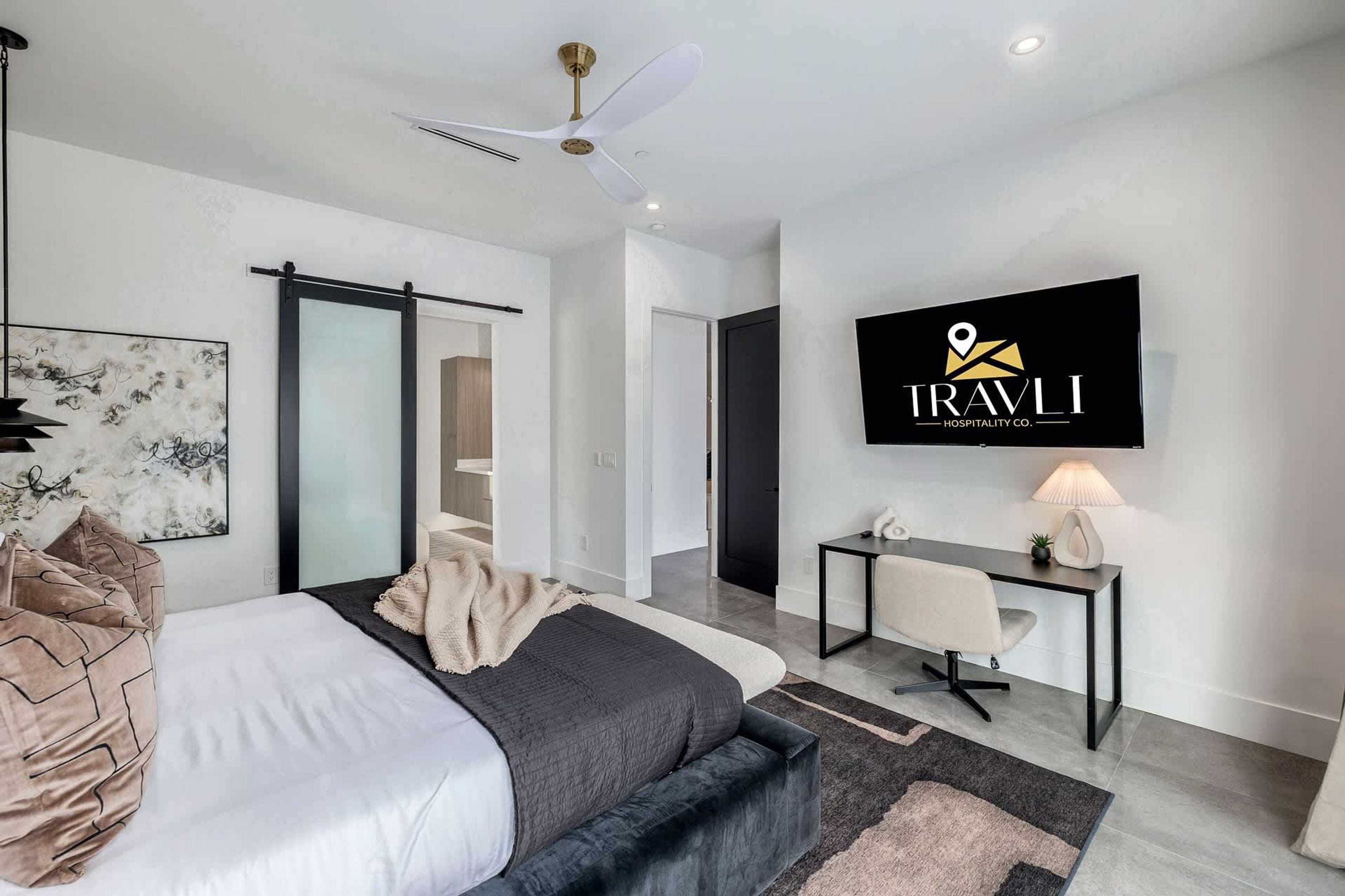Une chambre d’hôtel moderne équipée d’un lit, d’un bureau et d’une télévision.