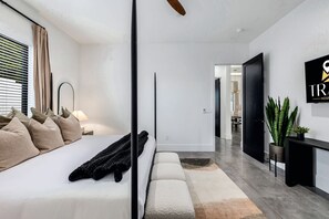 A modern hotel room with a bed, bedside table, lamp, and a view of the hallway. - The Carlisle Experience 4 Showers Heated Pool (Scottsdale)