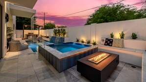 A modern outdoor living area with a hot tub, seating, and a fire feature. - The Carlisle Experience 4 Showers Heated Pool (Scottsdale)