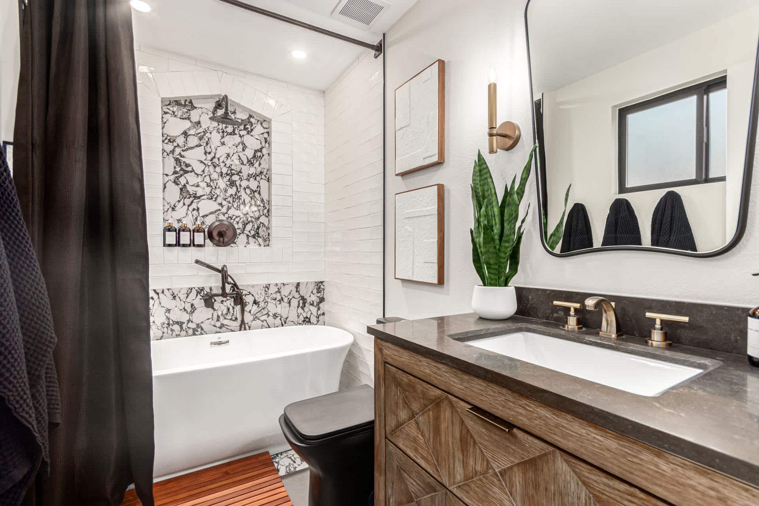 Une salle de bain moderne avec une baignoire sur pieds, un meuble-lavabo à deux vasques et un grand miroir.