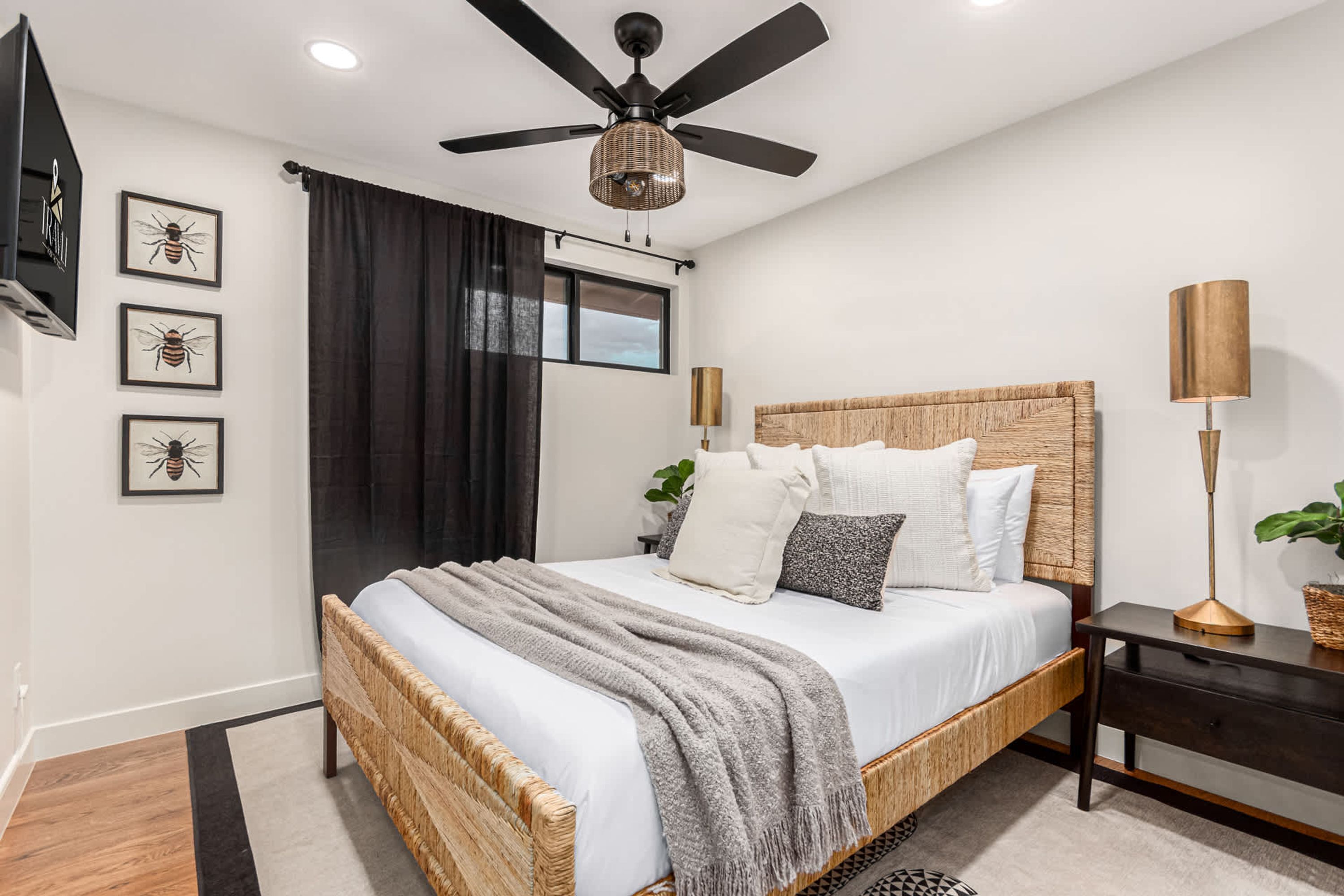 Una camera da letto moderna con un letto grande, un ventilatore a soffitto e un comodino con una lampada.
