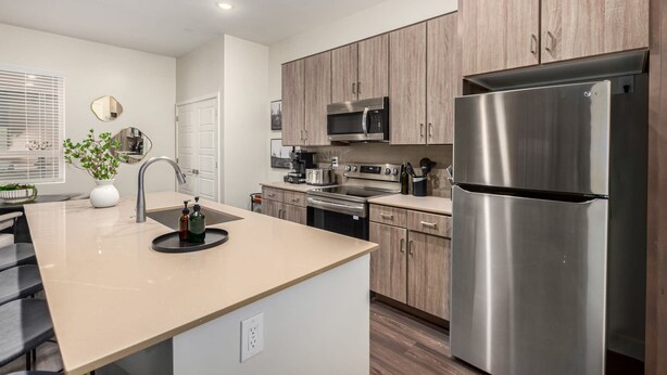 A modern kitchen with wooden cabinets, stainless steel appliances, and a central island with a sink. - Macallister 1007 N Scottsdale Close2golf Htd Pool (Scottsdale)