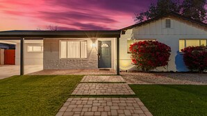 A modern house with a garage, a covered patio, and a well-maintained lawn. - Desert Diamond Oasis Private Pool Bar Games (Scottsdale)