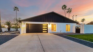 A modern house with a garage, a driveway, and palm trees. - Agave on Cactus Private Pool Firepit Sleeps 10 (Scottsdale)