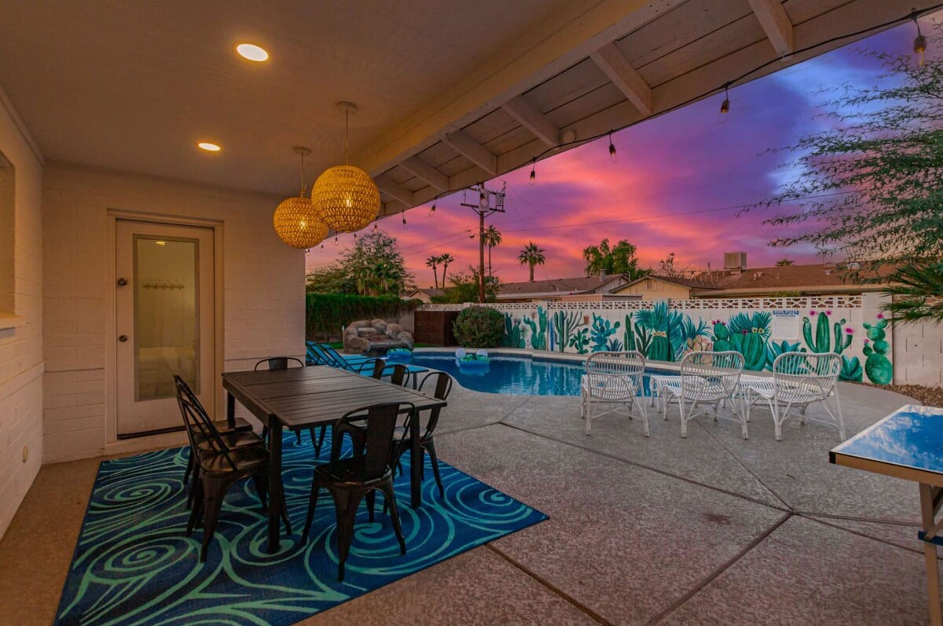 Eine Außenpatio mit Pool, Essbereich und einer Kakteen-Mural.