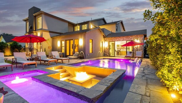 A modern house with a swimming pool, outdoor seating, and a stone patio. - Stonewood Luxe Estate 5 Showers Heated Pool GYM (Scottsdale)