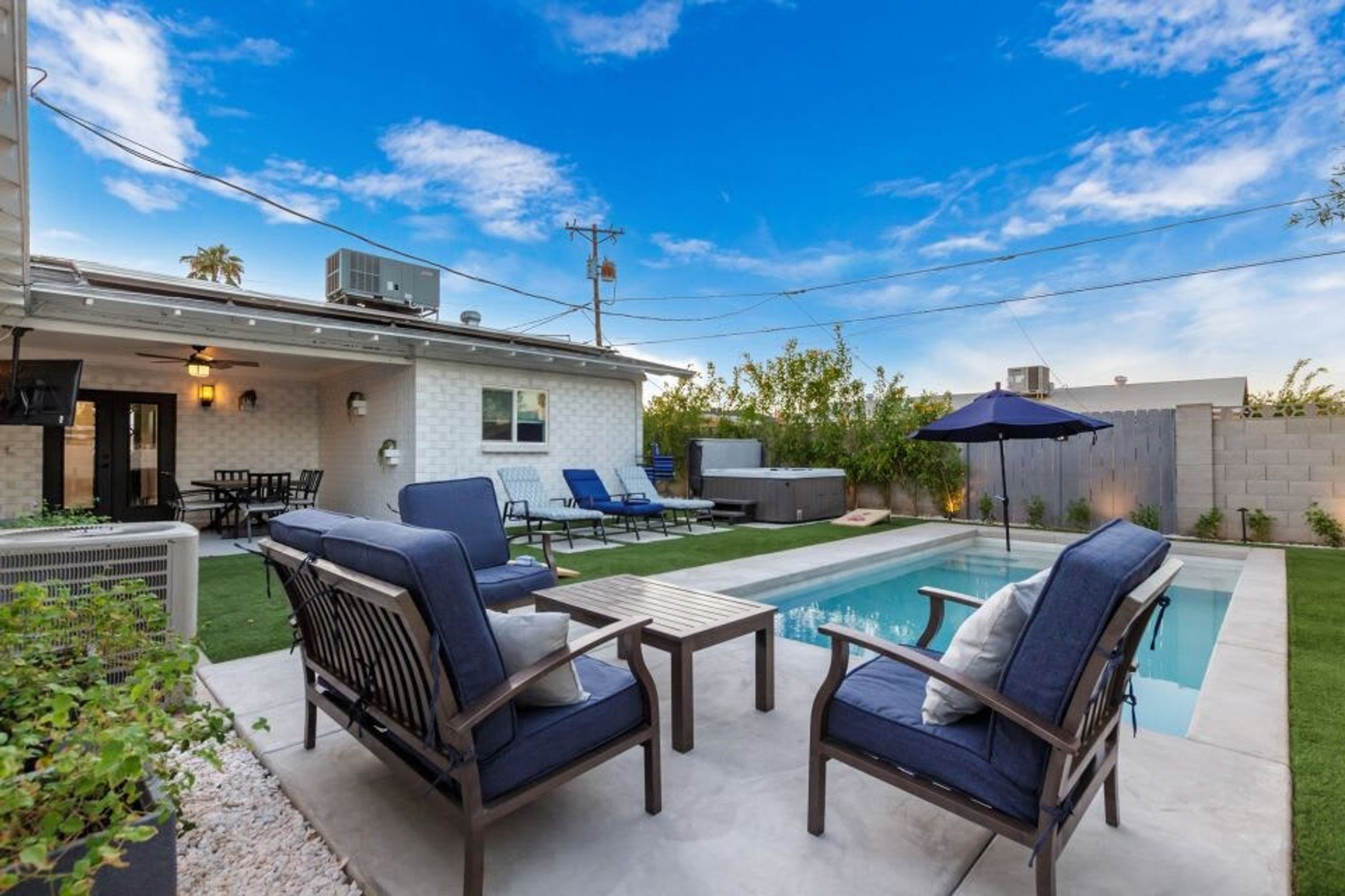 Ein Garten mit Schwimmbad, Gartenmöbeln und einer Terrasse.