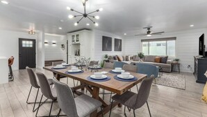 Un espace repas moderne avec une table en bois dressée pour quatre personnes, entourée de chaises grises.