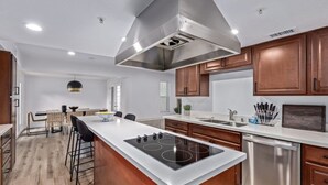 A modern kitchen with a central island, stainless steel appliances, and wooden cabinets.