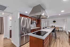 A modern kitchen with stainless steel appliances, a central island, and wooden cabinets. - 8BR Villa Heated Pool Putt Grn Billiards Sleeps 18 (Phoenix)