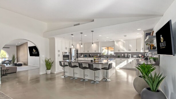 A modern kitchen with a central island, bar stools, and a large island bar. - 5BR Resort-style Oasis 2 Primary s Cabana Gameroom (Chandler)