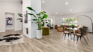 Un salón amplio con una planta grande, un tapiz de cuero y un conjunto de sofás moderno.